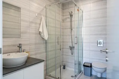 a bathroom with a sink and a glass shower at Valleria - 2 BR Apartment W Pool in Larnaca in Larnaka
