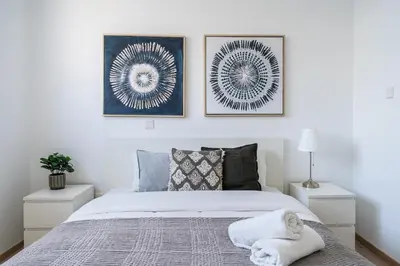 a bedroom with a bed and two pictures on the wall at Valleria - 2 BR Apartment W Pool in Larnaca in Larnaka