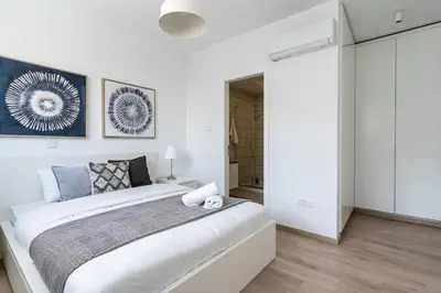 a white bedroom with a large bed in a room at Valleria - 2 BR Apartment W Pool in Larnaca in Larnaka