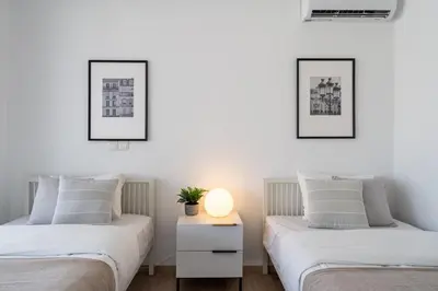 two beds in a bedroom with a lamp on a night stand at Valleria - 2 BR Apartment W Pool in Larnaca in Larnaka