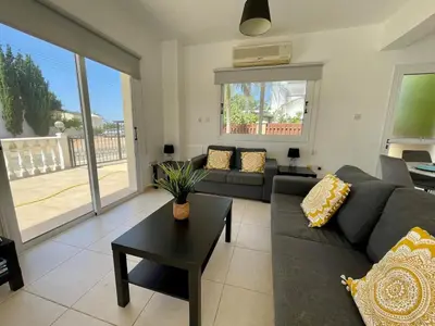 a living room with a couch and a table at Villa Scarlett, Ayia Thekla in Ayia Napa