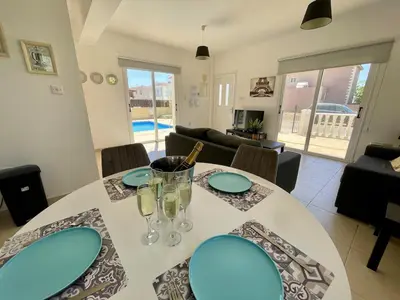 a dining room with a white table and chairs at Villa Scarlett, Ayia Thekla in Ayia Napa