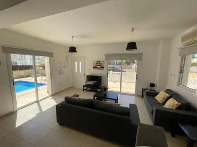 a living room with couches and a pool at Villa Scarlett, Ayia Thekla in Ayia Napa