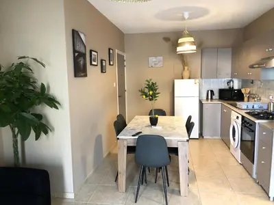 a kitchen with a table and chairs in a room at Cozy 2BR Beach Apt, Perfect for Getaways in Larnaka