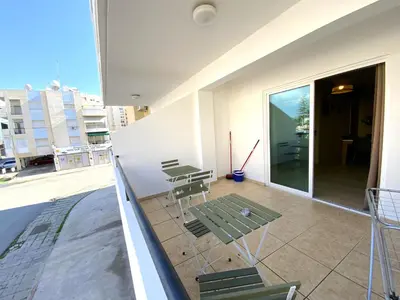 a balcony with chairs and tables on a building at Cozy 2BR Beach Apt, Perfect for Getaways in Larnaka