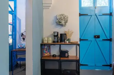 a room with blue doors and a table with a toaster at Blue Haven - 2-BR Artistic Escape in Larnaca in Larnaka