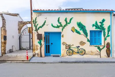 a building with a blue door and a bike painted on it at Blue Haven - 2-BR Artistic Escape in Larnaca in Larnaka