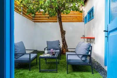 two chairs and a table next to a tree at Blue Haven - 2-BR Artistic Escape in Larnaca in Larnaka