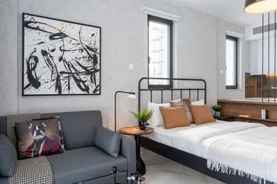 a bedroom with a bed and a chair at Dusk - Harmonic Studio by Plus 49 in Mackenzie in Larnaka