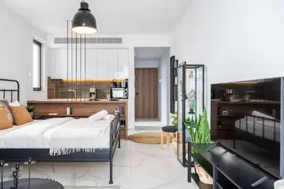a bedroom with a bed and a kitchen at Dusk - Harmonic Studio by Plus 49 in Mackenzie in Larnaka