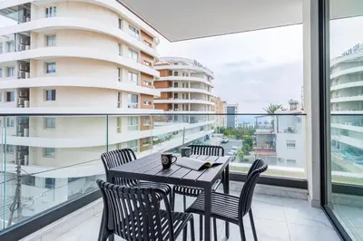 a dining room with a table and chairs on a balcony at Dusk - Harmonic Studio by Plus 49 in Mackenzie in Larnaka