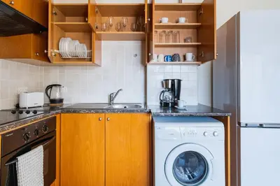 a kitchen with a washing machine and a washer at Glade - 1 Bedroom Apt W Balcony in Larnaca in Larnaka