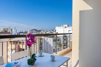 a table with a vase of flowers on a balcony at Glade - 1 Bedroom Apt W Balcony in Larnaca in Larnaka