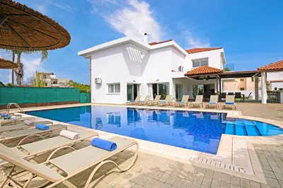 a villa with a swimming pool and lounge chairs at Nissi Diamond Mansion in Ayia Napa