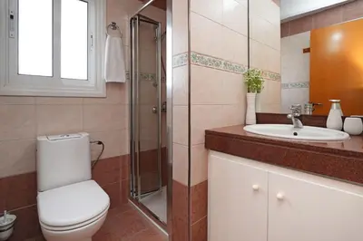 a bathroom with a toilet and a sink and a shower at Nissi Diamond Mansion in Ayia Napa