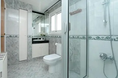 a bathroom with a toilet and a glass shower at Nissi Diamond Mansion in Ayia Napa