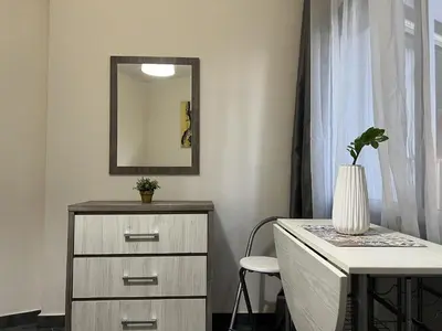 a dresser with a mirror next to a desk with a plant at two-room apartment center in Limassol