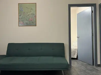 a green couch in a room with a mirror at two-room apartment center in Limassol