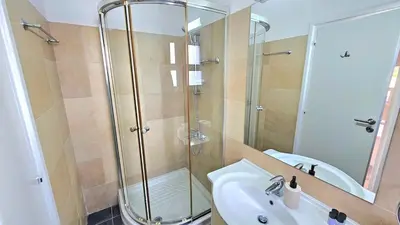 a bathroom with a glass shower and a sink at White Cove Villa, Limassol in Pyrgos