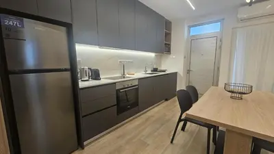 a kitchen with a stainless steel refrigerator and a table at STAY City Center Gem in Nicosia
