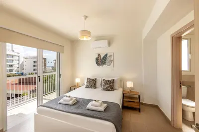 a bedroom with a bed and a balcony at Protaras Villa Cemelia in Protaras