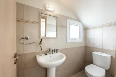 a bathroom with a sink and a toilet and a mirror at Protaras Villa Cemelia in Protaras