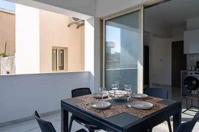 a black table with glasses and plates on it at Marble - Cozy Studio W Balcony in Larnaca in Larnaka