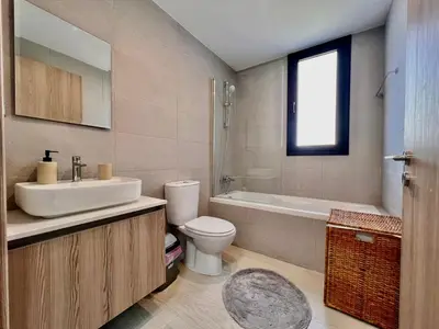 a bathroom with a sink and a toilet and a tub at Mackenzie Seaside Apartment in Larnaka