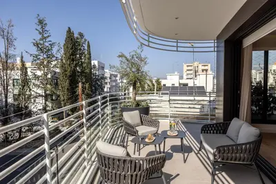 a balcony with chairs and a table on a building at Elysium Heights in Nicosia