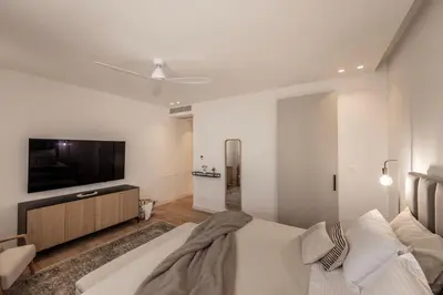 a bedroom with a bed and a flat screen tv at Elysium Heights in Nicosia