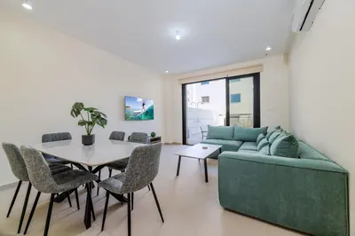 a living room with a green couch and a table at Quattro Rise in Paralimni