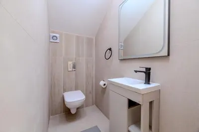 a bathroom with a toilet and a sink and a mirror at Quattro Rise in Paralimni