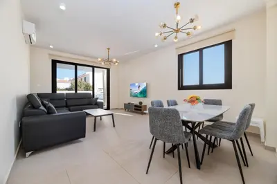 a living room with a couch and a table and chairs at Quattro Rise in Paralimni