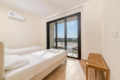 a bedroom with two beds and a large window at Quattro Rise in Paralimni