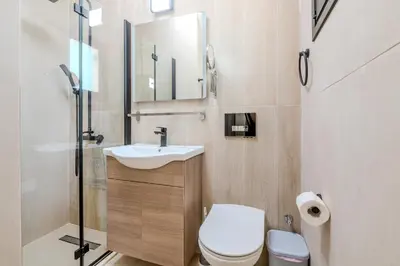 a bathroom with a sink and a toilet and a mirror at Quattro Rise in Paralimni