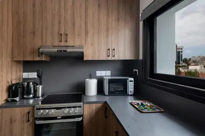 a kitchen with a stove top oven next to a window at Urban Condo 33 with Balcony - 2 Bdr in Nicosia
