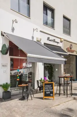 a restaurant with tables and chairs in front of a building at Urban Condo 33 with Balcony - 2 Bdr in Nicosia