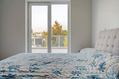 a bedroom with a bed and a large window at Penthouse Great View Hydromassage Penthouse hottub in Limassol