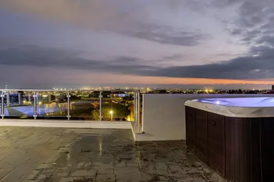a balcony with a view of an airport at night at Penthouse Great View Hydromassage Penthouse hottub in Limassol