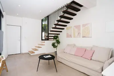 a living room with a couch and a staircase at WealthyStays 2BR Retreat , 5Min Walk to Beach in Protaras