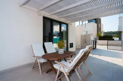 a wooden table and four chairs on a patio at WealthyStays 2BR Retreat , 5Min Walk to Beach in Protaras