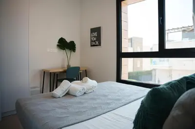 a bedroom with two towels on a bed with a window at WealthyStays 2BR Retreat , 5Min Walk to Beach in Protaras