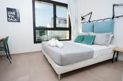 a bedroom with a bed and a desk and a window at WealthyStays 2BR Retreat , 5Min Walk to Beach in Protaras