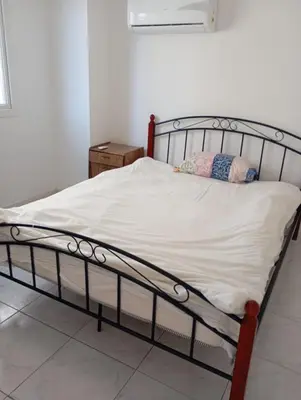 a bed with a metal frame in a room at Eat well Sleep Well in Larnaka