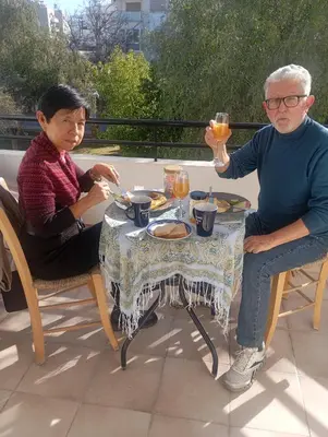 a man and woman sitting at a table with drinks at Eat well Sleep Well in Larnaka