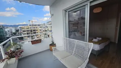 a balcony with a white chair and a bed at STAY Velvet Apartment in Limassol