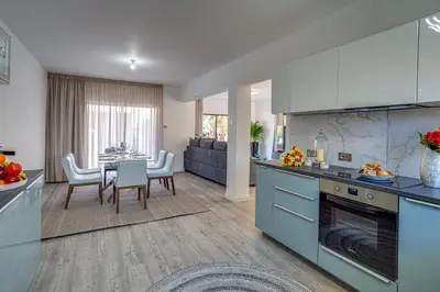 a kitchen with blue cabinets and a table with chairs at Perle Di Gio in Larnaka