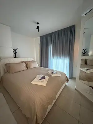 a bedroom with a large bed with two towels on it at FLH - Feel Like Home Modern 1-Bedroom Ground floor Apartment in Strovolos in Kato Lakatamia