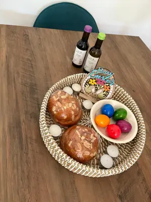 a basket of easter eggs and wine bottles on a table at FLH - Feel Like Home Modern 1-Bedroom Ground floor Apartment in Strovolos in Kato Lakatamia