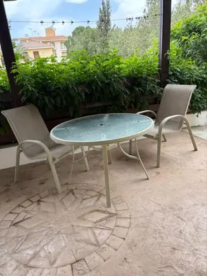 two chairs and a glass table on a patio at FLH - Feel Like Home Modern 1-Bedroom Ground floor Apartment in Strovolos in Kato Lakatamia